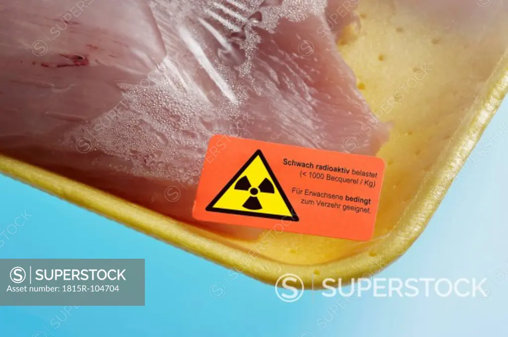 Turkey steaks with radioactive warning sticker on blue background