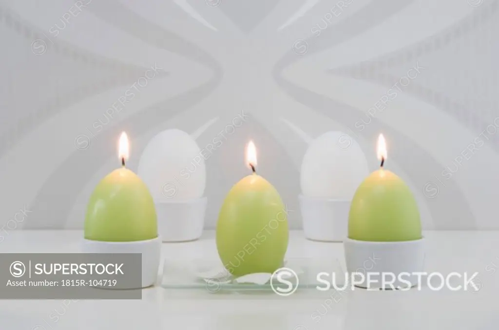 Egg shape candle and easter egg in cup, close up