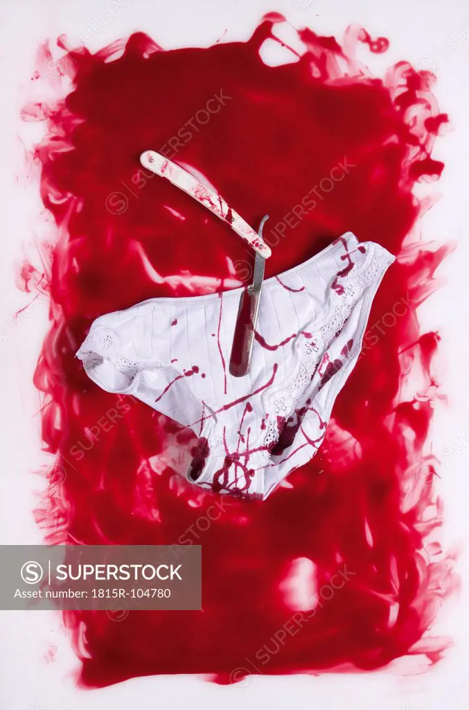 Razor and slip in blood on white background