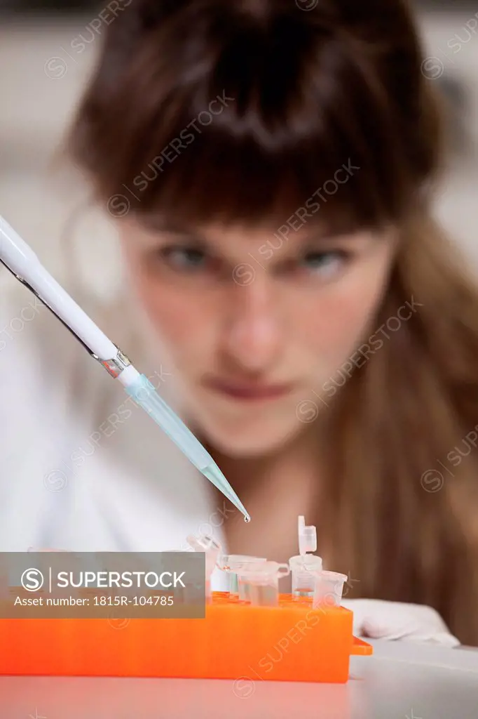 Germany, Bavaria, Munich, Scientist with pipette and test tubes in laboratory