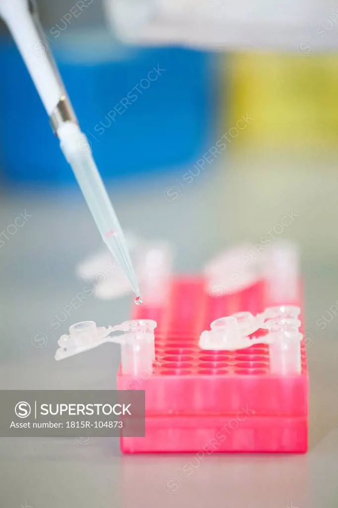 Germany, Bavaria, Munich, Droplet being dispensed from pipette into test tube