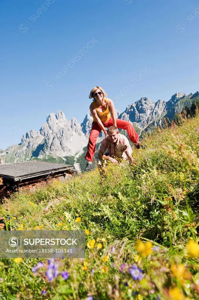 Austria, Salzburg, Filzmoos, Couple having fun in alpine meadow