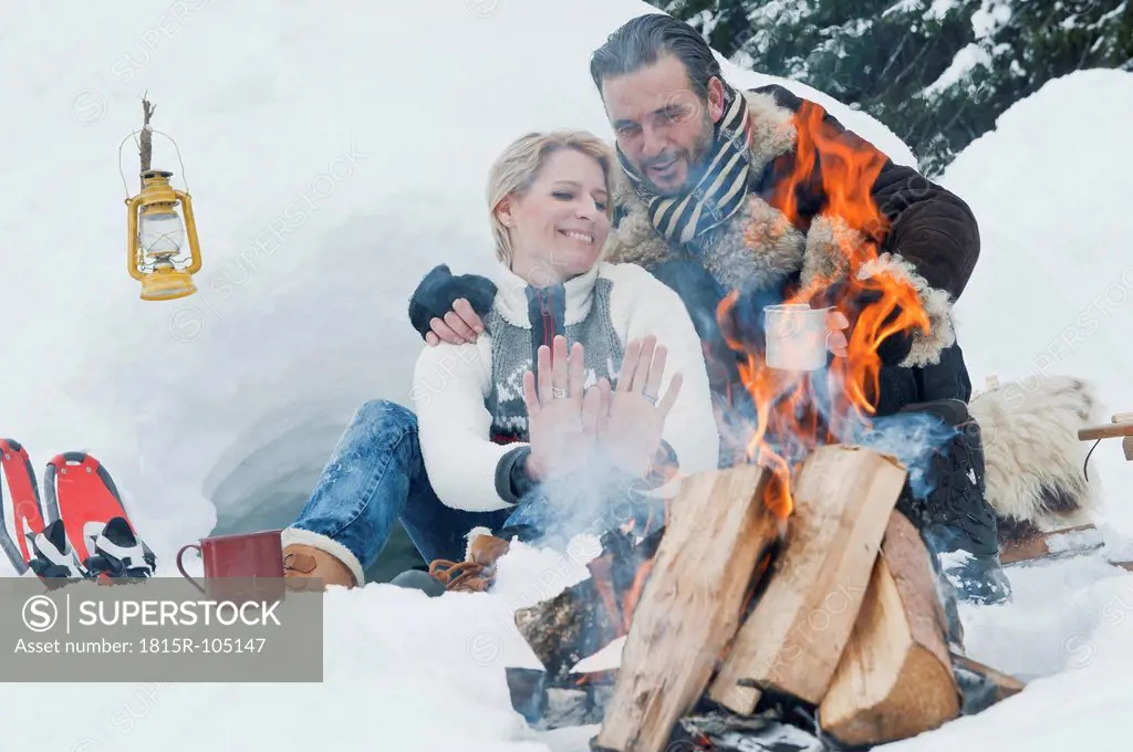 Austria, Salzburg County, Couple sitting near fireplace