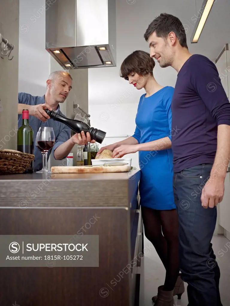 Germany, Cologne, Men and woman cooking together in kitchen