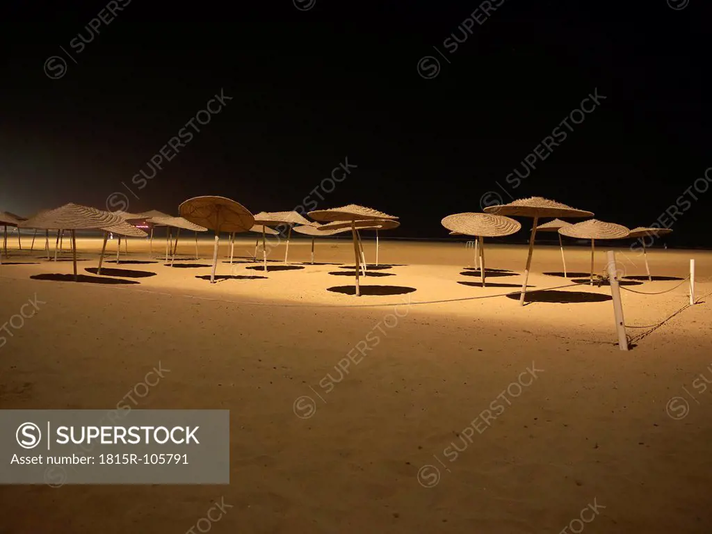 Morocco, Essaouira, Sunshades on beach at night