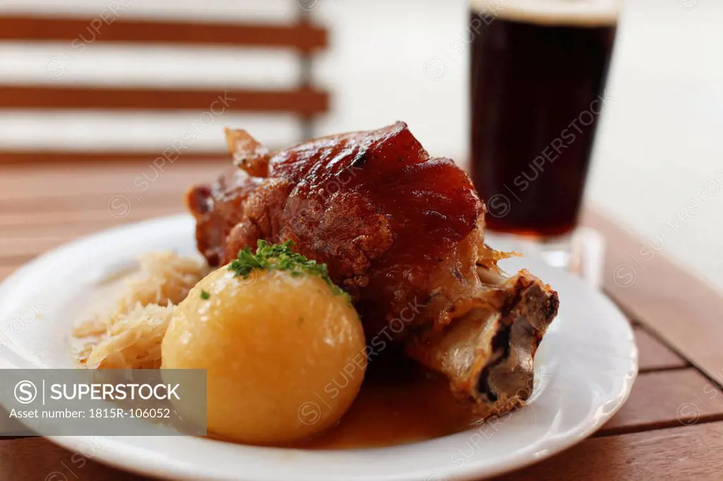 Germany, Bavaria, Bamberg, knuckle of pork with potato dumpling in plate, close up