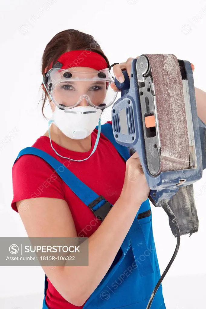 Young woman holding electric planer, portrait