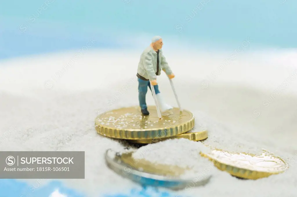 Figurines of handicapped patient on beach with euro coin