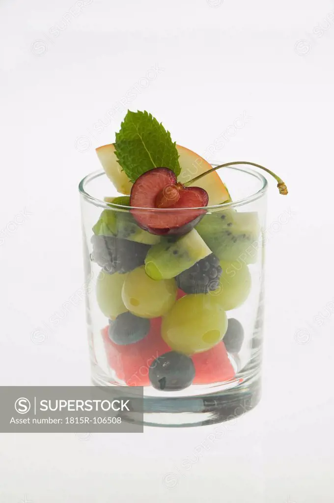 Glass of fruit salad on white background