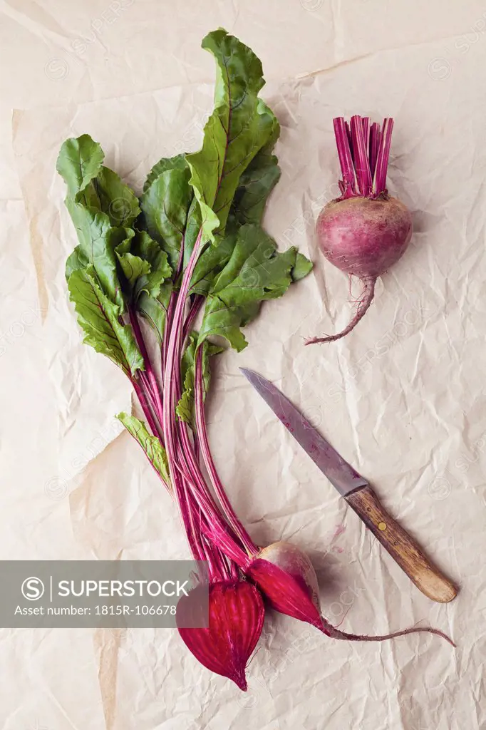 Beetroots with knife on parchment paper