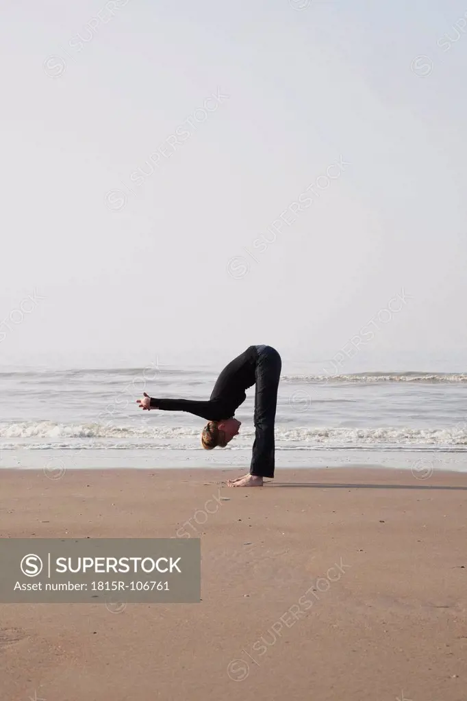 Belgium, Young woman exercising at North Sea