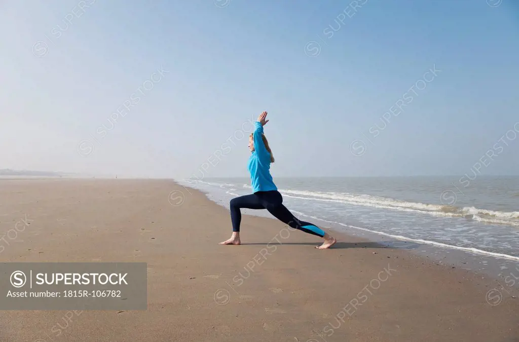 Belgium, Mature woman exercising at North Sea
