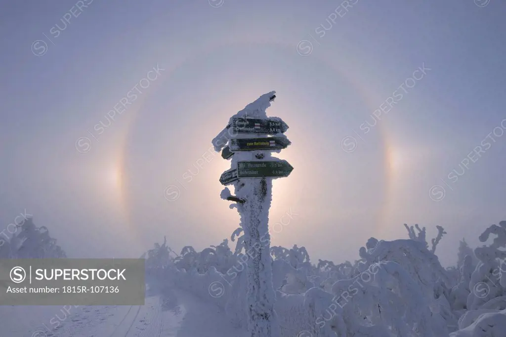 View of sundog with directional sign in snowy landscape
