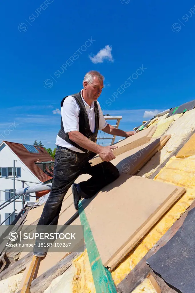Germany, Baden_Wuerttemberg, Stuttgart, Mature man placing insulation