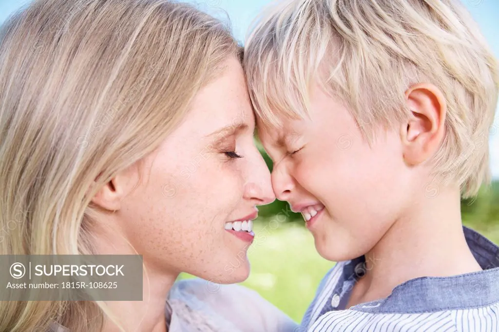 Germany, Cologne, Mother and son touching forehead, close up