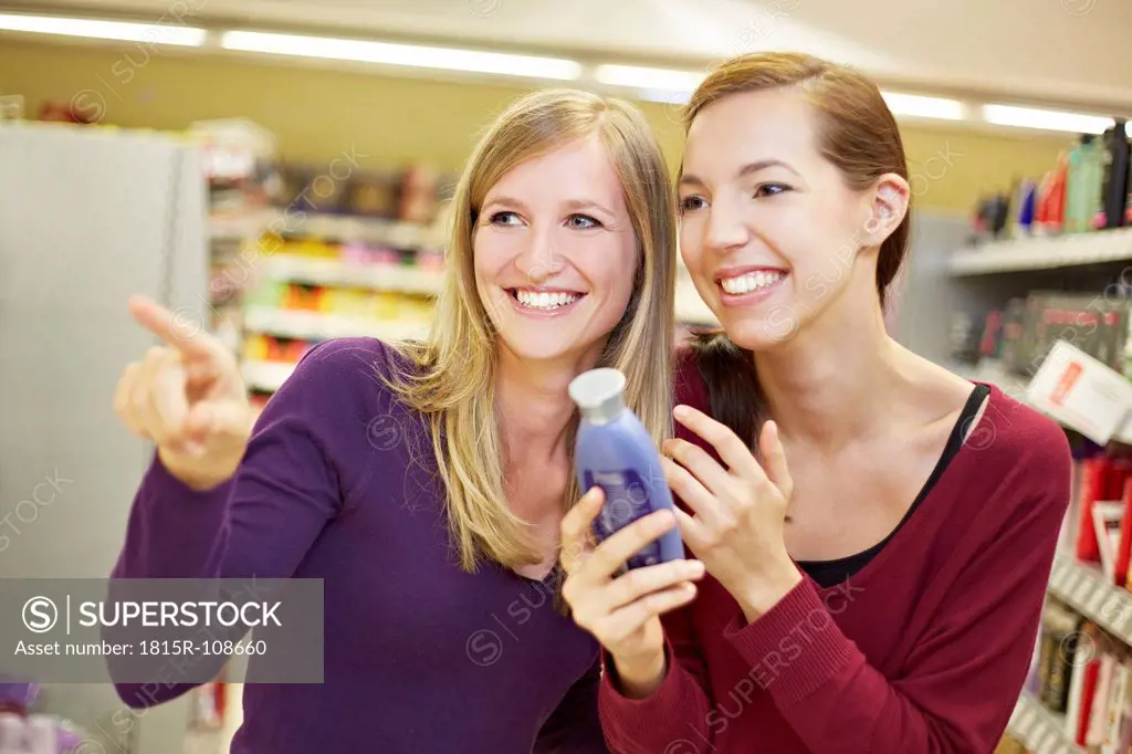 Germany, Cologne, Young women in supermarket, smiling
