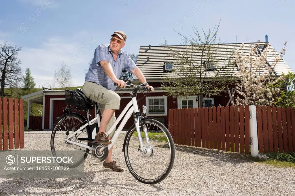 Germany, Bavaria, Senior man riding electric bicycle