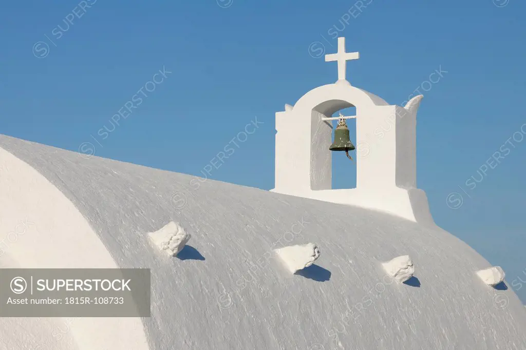 Greece, Whitewashed traditionally Greek church with bell tower and cross in Oia at Santorini