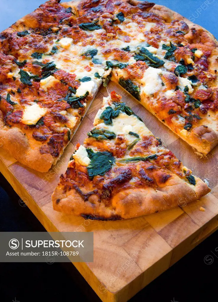Italian spinach and ricotta cheese pizza on wooden board