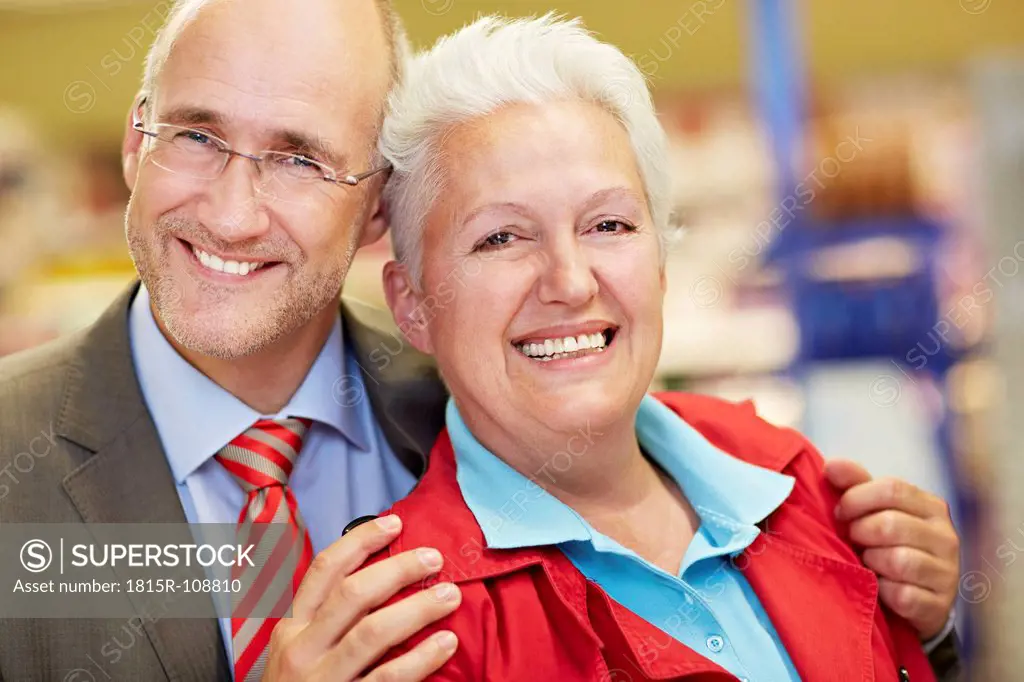 Germany, Cologne, Mature couple in supermarket, smiling, portrait