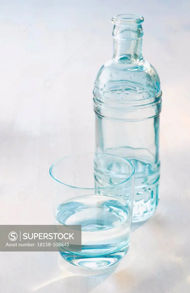 Bottle and glass with water, close up