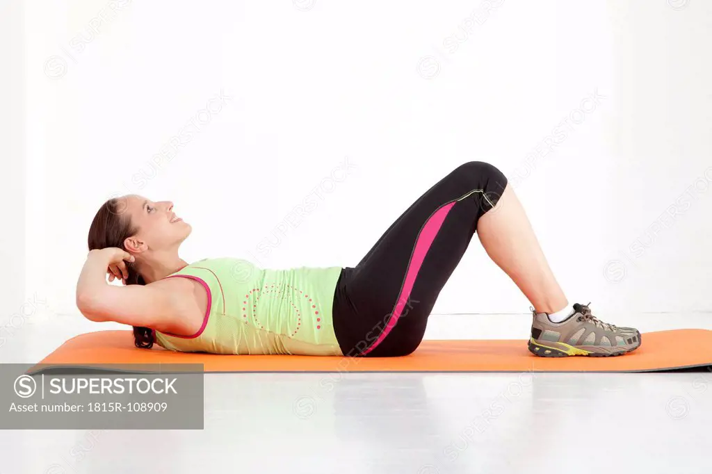 Young woman doing sit_ups on exercise mat