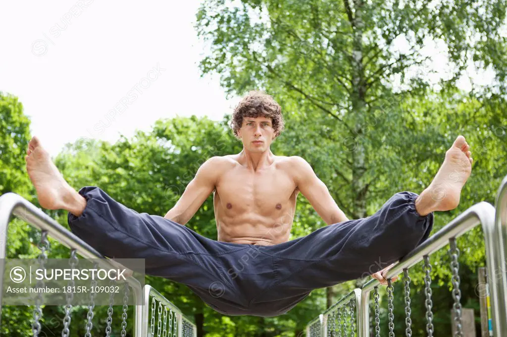 Germany, Bavaria, Young man exercising on railing