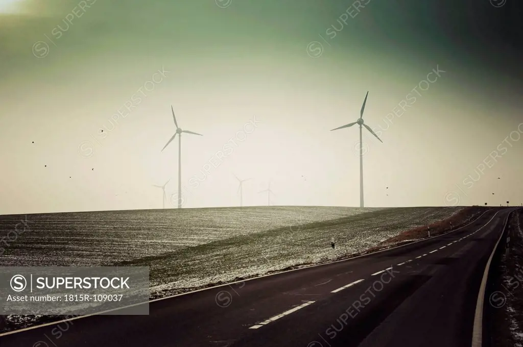 Germany, Saxony, View of empty road with wind turbine