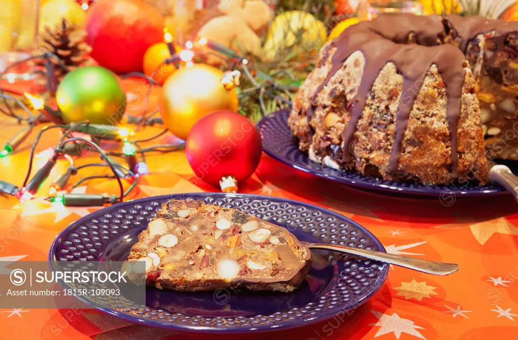 Plate of Christmas fruit cake slice with christmas decoration in background