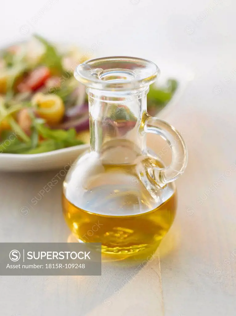 Oil bottle in front of an salad
