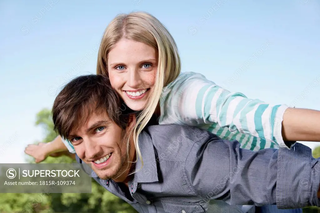 Germany, Cologne, Young couple flying, smiling, portrait