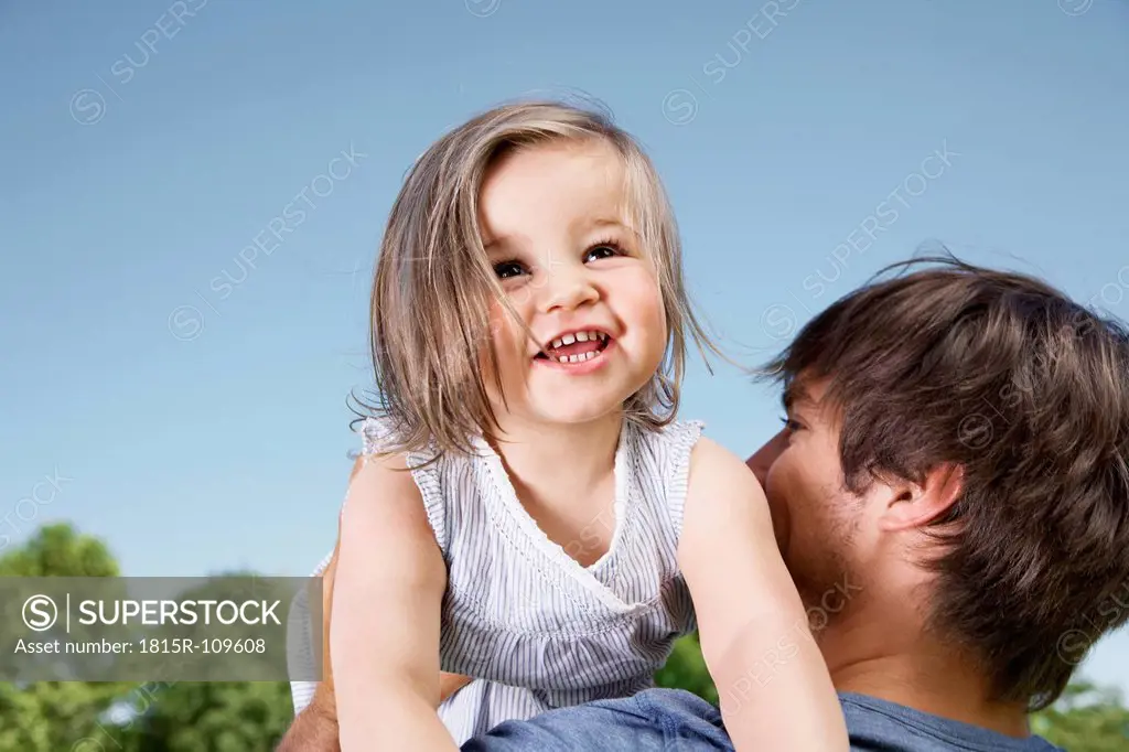 Germany, Cologne, Father holding her daughter, smiling