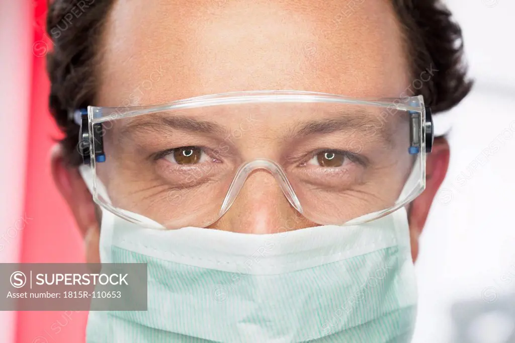 Germany, Dentist with safety glasses and surgical mask in dental office