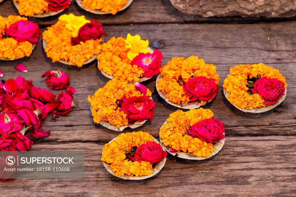 India, Uttar Pradesh, Leaf bowls with flowers and oil lamp for Aarti at Ganges river