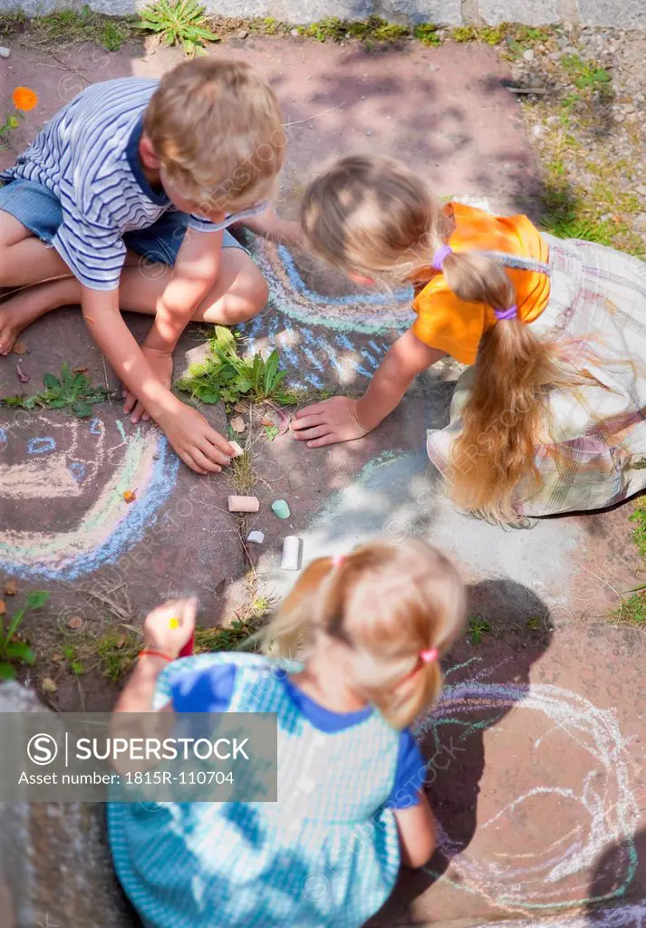 Germany, Bavaria, Group of children drawing on walkway with chalk