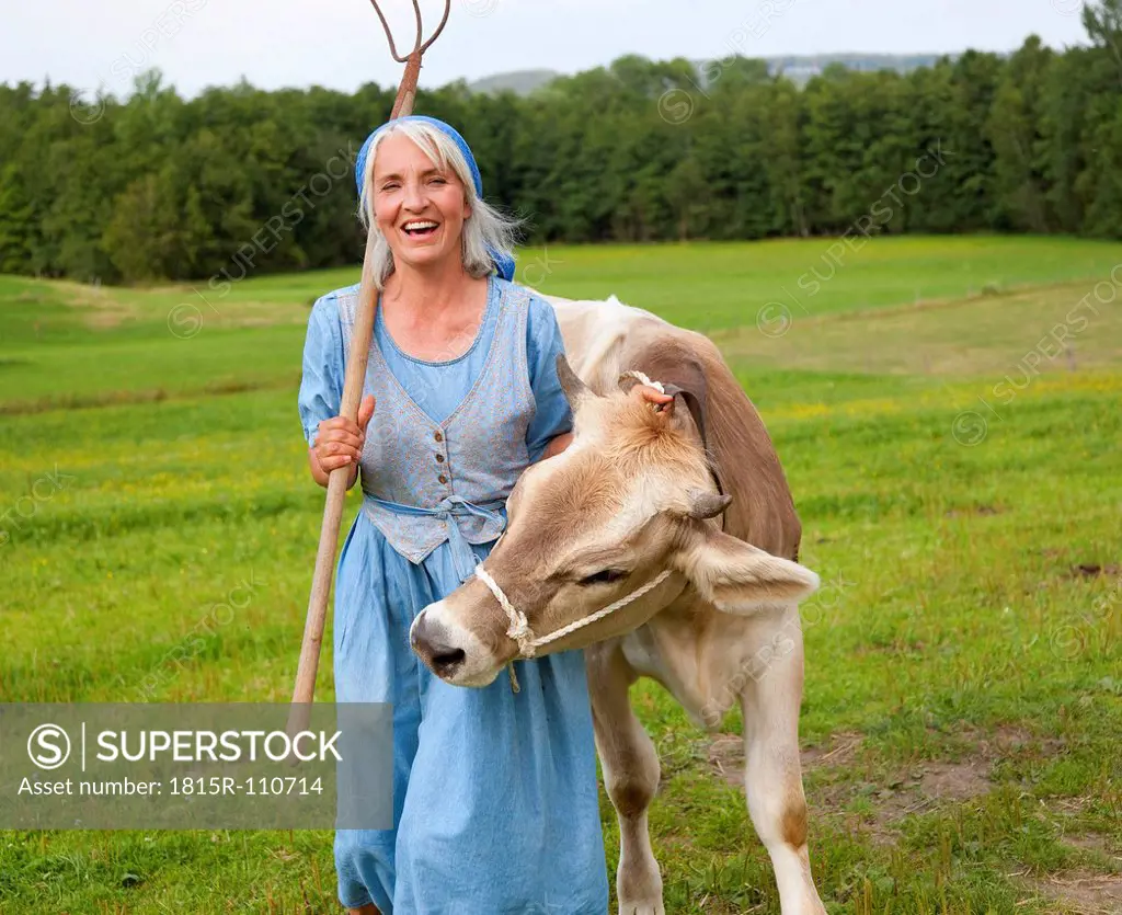 Germany, Bavaria, Mature woman with cow on farm