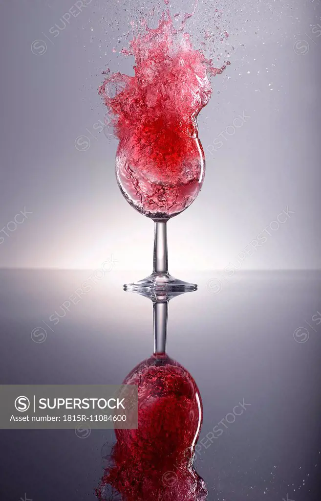 Red wine splashing in glass