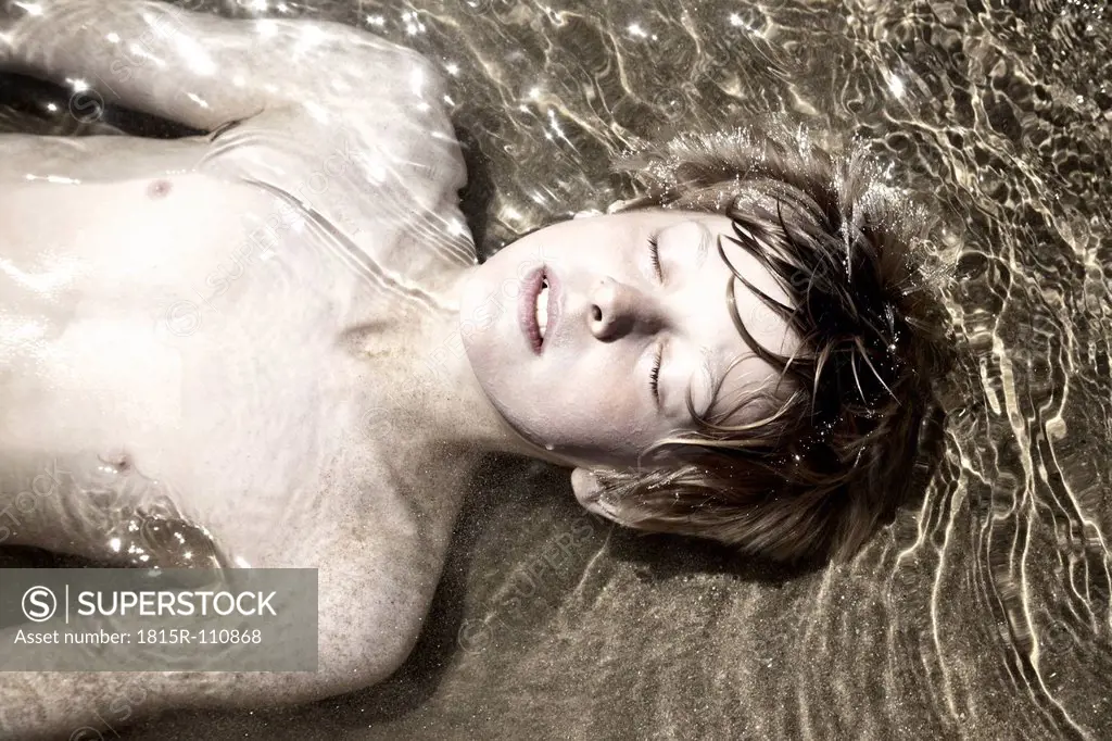 France, Boy lying in sea