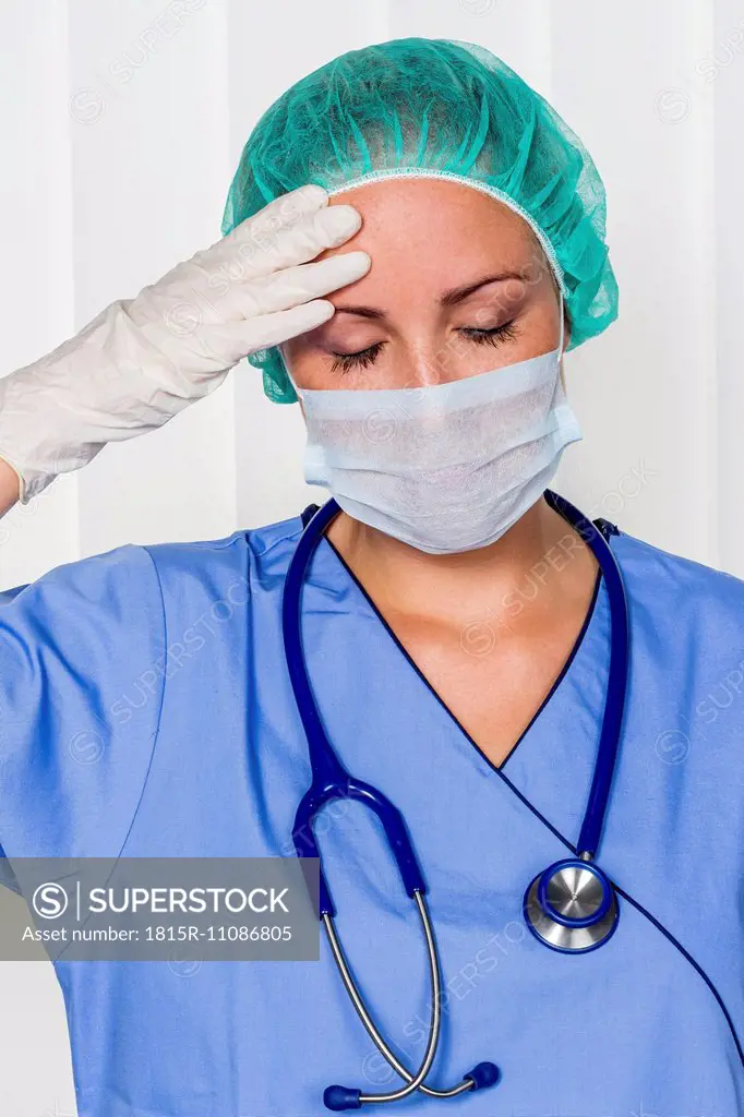 Exhausted doctor in surgical gown
