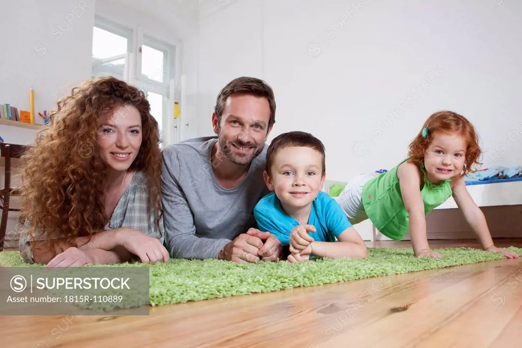 Germany, Berlin, Family relaxing on floor, smiling, portrait