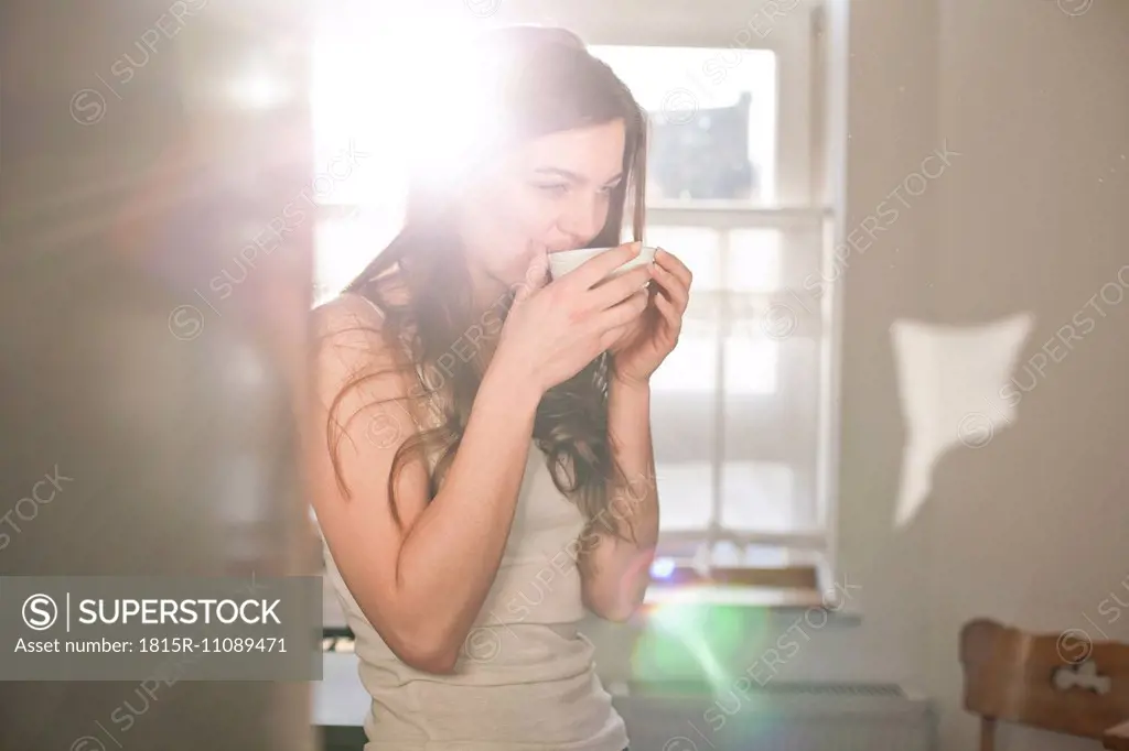 Portrait of young woman drinking tea in the morning