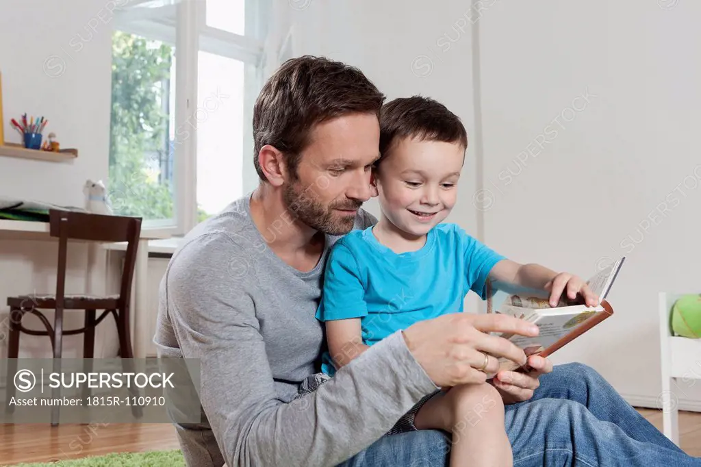 Germany, Berlin, Father and son reading book