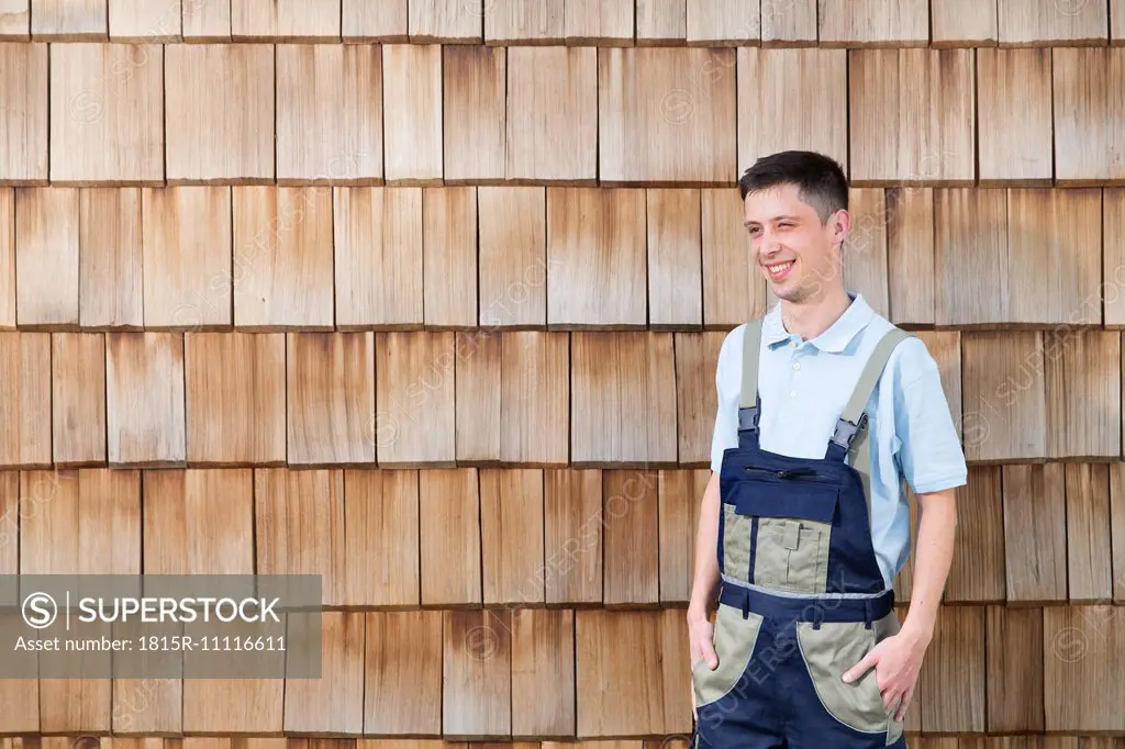 Confident craftsman at wooden wall