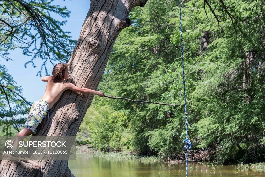 USA, Texas, Boy with stick at Frio River