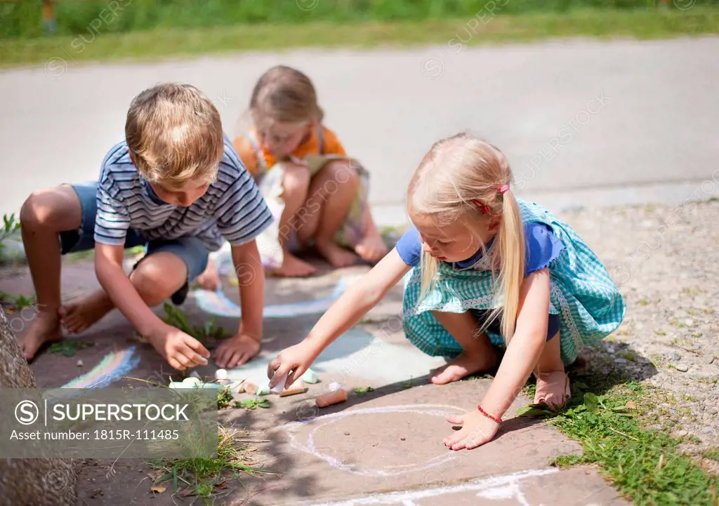 Germany, Bavaria, Group of children drawing on walkway with chalk