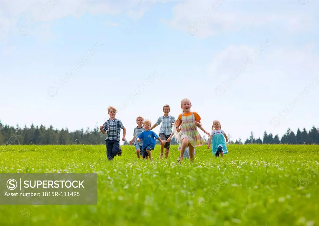 Germany, Bavaria, Group of children running through meadow