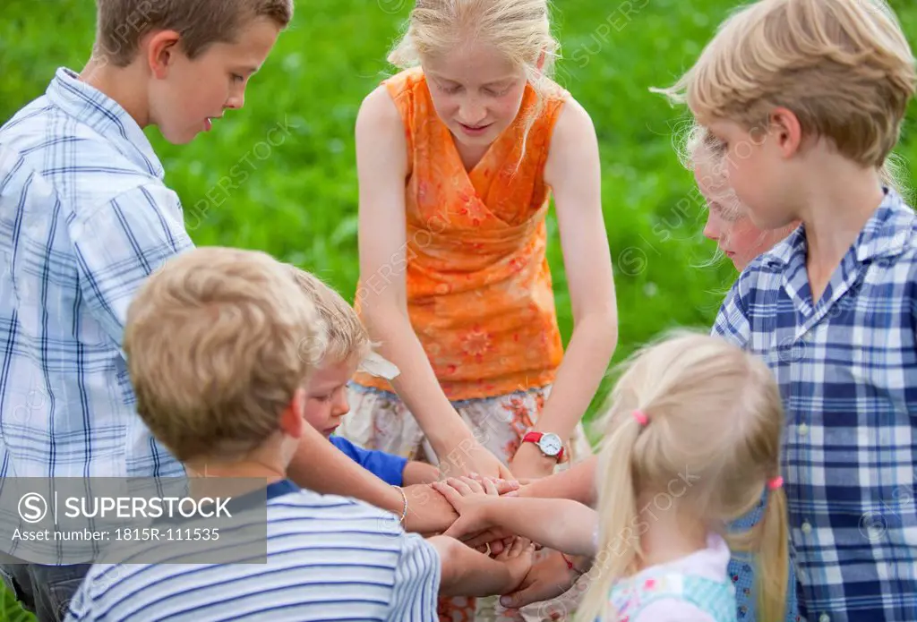 Germany, Bavaria, Group of children putting hands together