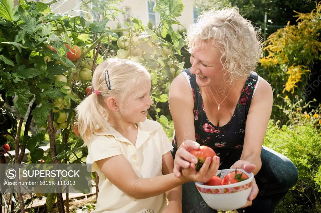 Germany, Bavaria, Grandmother and granddaughter working in vegetable garden