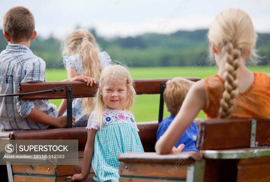 Germany, Bavaria, Group of children sitting on cart