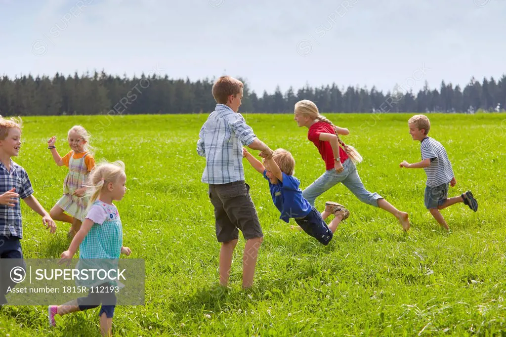 Germany, Bavaria, Group of children playing in meadow